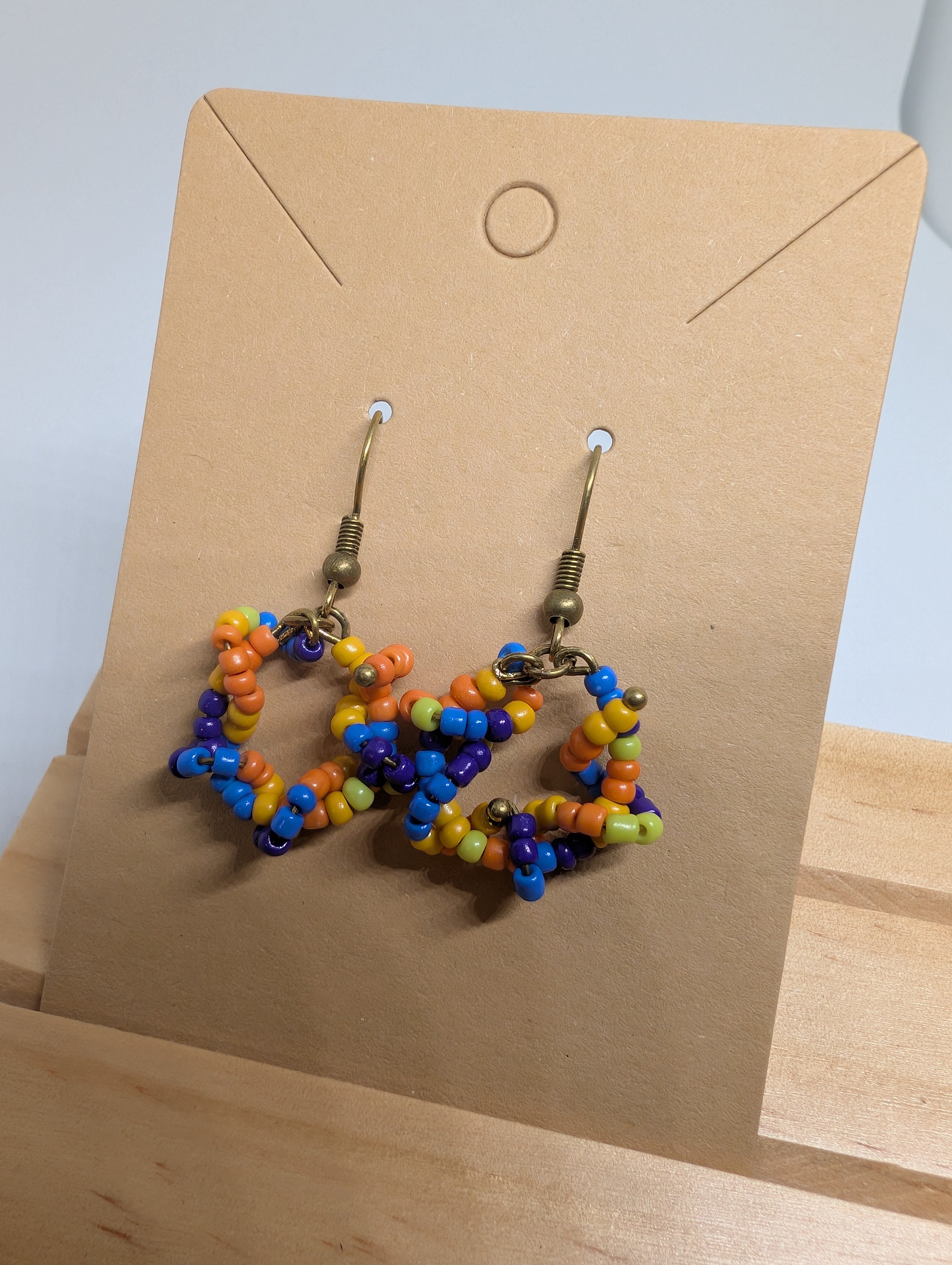 Rainbow Star Dangles, handmade beaded earrings in multicolour, purple, orange and bronze